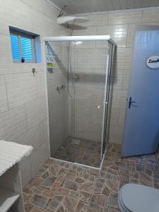 a shower with a glass door in a bathroom at Casa Amarela in Lages