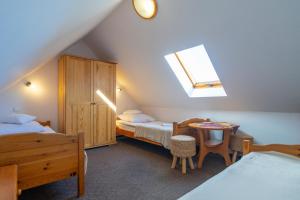 a attic bedroom with two beds and a table at Willa Anna Maria in Szklarska Poręba