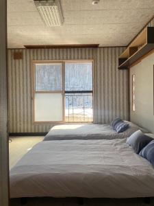 - une chambre avec 2 lits et une grande fenêtre dans l'établissement Sound Garden Biei, Forest, à Shibinai