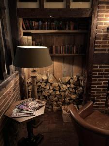 una lámpara sentada en una mesa junto a un montón de madera en The Leicester Arms Country Inn, en Penshurst