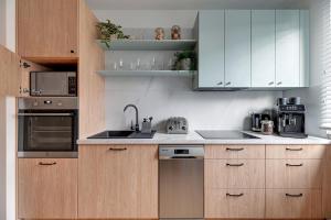 a kitchen with wooden cabinets and stainless steel appliances at Lion Apartments - Amalfi Quiet Family 3 Bedr Apartment in Sopot