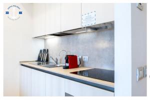 una cocina con armarios blancos y un aparato rojo en Eurosky Nine View, en Roma