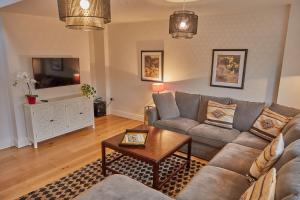 a living room with a couch and a tv at Swan's Nest in Henley on Thames