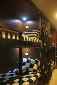 two bunk beds in a room with a checkered floor at J & J Homestay in Coron