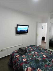 1 dormitorio con 1 cama y TV en la pared en A 10 min de la playa y con excelentes zonas comunes, en Benalmádena