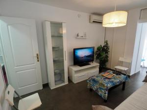 una sala de estar con TV y mesa y una habitación en A 10 min de la playa y con excelentes zonas comunes, en Benalmádena