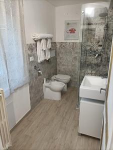 uma casa de banho com um WC, um chuveiro e um lavatório. em La dimora del capitano em Quattordio