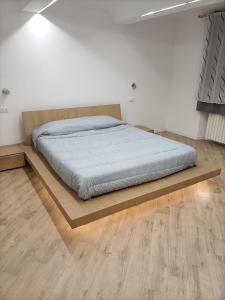 uma cama numa plataforma de madeira num quarto em La dimora del capitano em Quattordio