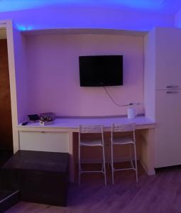a room with a desk with a tv on a wall at La dimora del capitano in Quattordio