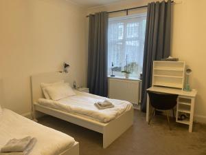 a bedroom with a bed and a desk and a window at Ground Floor 2 Bed Holiday Flat in Eastbourne