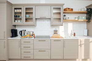 a white kitchen with white cabinets and appliances at Swan's Nest in Henley on Thames