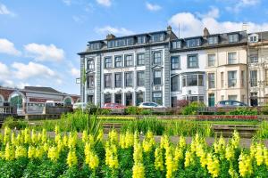 un grande edificio con fiori gialli di fronte di The Victoria Hotel a Scarborough