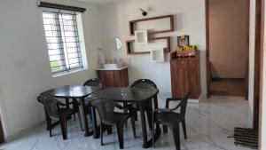 a dining room with a black table and chairs at Stellar homes Ooty in Ooty