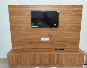 a flat screen tv sitting on top of a wooden entertainment center at Stellar homes Ooty in Ooty