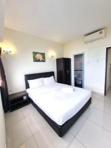a bedroom with a large white bed in a room at Green Ocean Seaview Apartment in Batu Ferringhi