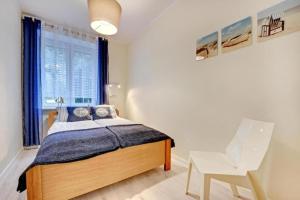 a bedroom with a bed and a chair and a window at UrbanNestGroup & Sw35/36 in Gdańsk