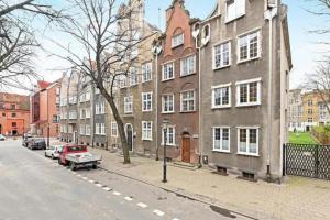 a building on a street with cars parked in front of it at UrbanNestGroup & Sw35/36 in Gdańsk