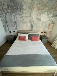 a bedroom with a large bed with two red pillows at La Casina di Cinzia in San Gimignano