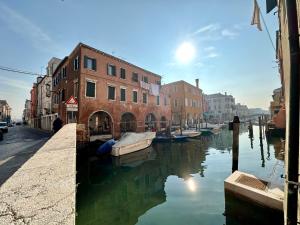 a canal in a city with boats in the water at Sora al Ponte in Chioggia