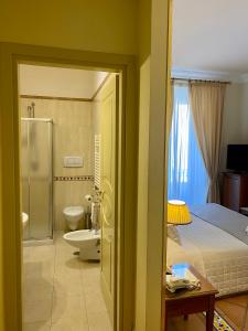 a bathroom with a bed and a toilet and a shower at Hotel Akropolis - Museum Hotel in Taranto