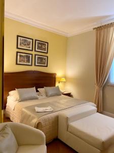 1 dormitorio con 2 camas y 1 silla en Hotel Akropolis - Museum Hotel, en Taranto