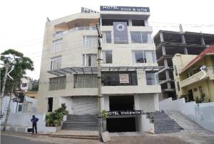 a man standing in front of a building at HOTEL BLACK & WHITE in Visakhapatnam