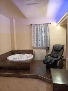 uma casa de banho com uma banheira e uma cadeira em La dimora del capitano em Quattordio