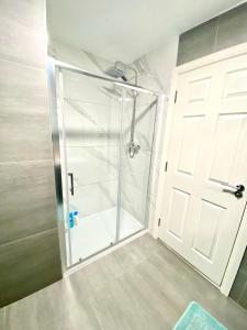 a shower with a glass door in a bathroom at One Bedroom Apartment In Ealing London in Ealing