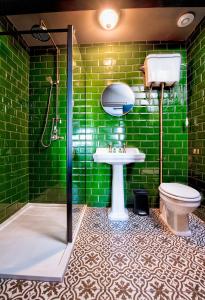 a green bathroom with a sink and a toilet at The Victoria Hotel in Scarborough