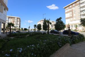 a person sitting on a sidewalk next to a field of flowers at DLX03 - Appartement Deluxe 2 chambres - Centre Ville Oujda in Oujda