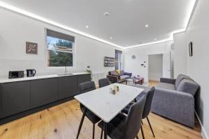 a kitchen and a living room with a table and chairs at Brand new Apartment near London Bridge LR1 in London
