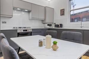 a kitchen with a white table with a candle on it at Brand new Apartment near London Bridge LR1 in London