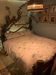 1 dormitorio con 1 cama con cabecero de árbol en Barn Cottage Quirky Weaver's Cottage in Quaint Hamlet, en Holmfirth