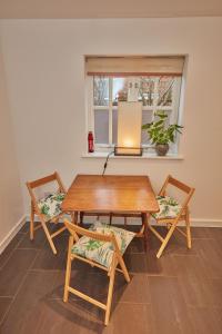 une table en bois avec deux chaises et une fenêtre dans l'établissement Mews house in the centre of Henley-on-Thames, à Henley-on-Thames