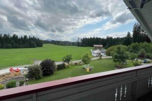 a view of a large green field from a balcony at Ferienwohnung am Bauernhof in Wald