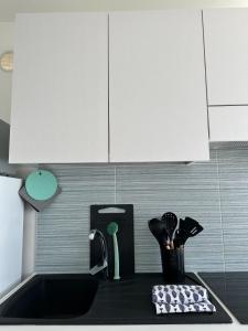 un bancone della cucina con lavello e armadietti bianchi di Floating House Anfora a Grado