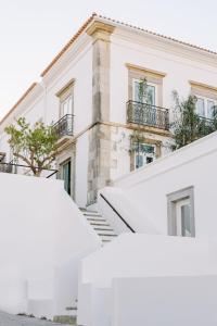 a white building with stairs in front of it at Colégio Charm House in Tavira