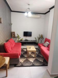 a living room with two red couches and a tv at Hurghada City Apartment1 in Hurghada