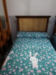 a bed with a green comforter with rabbits on it at Hurghada City Apartment1 in Hurghada