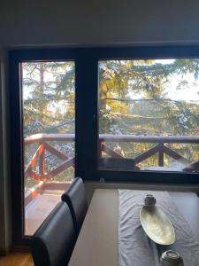 a dining room with a table and two large windows at Apartman Bianca in Palisad