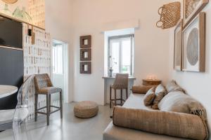 a living room with a couch and some chairs at Colégio Charm House in Tavira