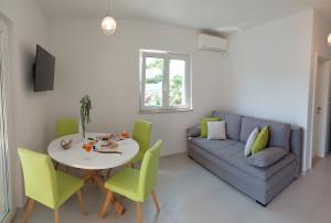 a living room with a couch and a table and chairs at Slano Bay Apartments in Slano