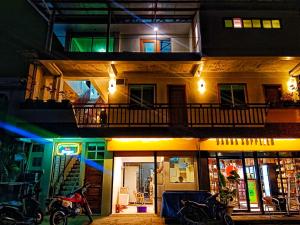 due immagini di un edificio di notte di #1 Green Room Inn Siargao a General Luna