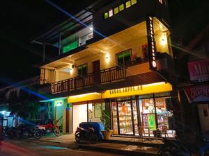 a building with a motorcycle parked in front of it at night at #1 Green Room Inn Siargao in General Luna