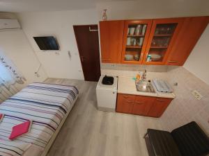 uma pequena cozinha com uma cama e um lavatório em Rooms Neda em Izola