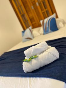 dos toallas blancas sentadas encima de una cama en Hospedaria Morada das Orquídeas, en São Sebastião