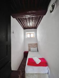 un piccolo letto in una piccola camera con soffitto di Riad Yamna a Rabat