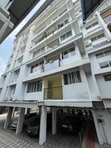 um edifício branco com dois carros estacionados em frente em MSK Gardenia Service Apartments em Cochin