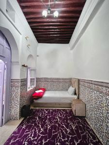 een bed in een kamer met een paars tapijt bij Riad Yamna in Rabat