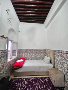 Riad Yamna في الرباط: سرير صغير في غرفة مع نافذة